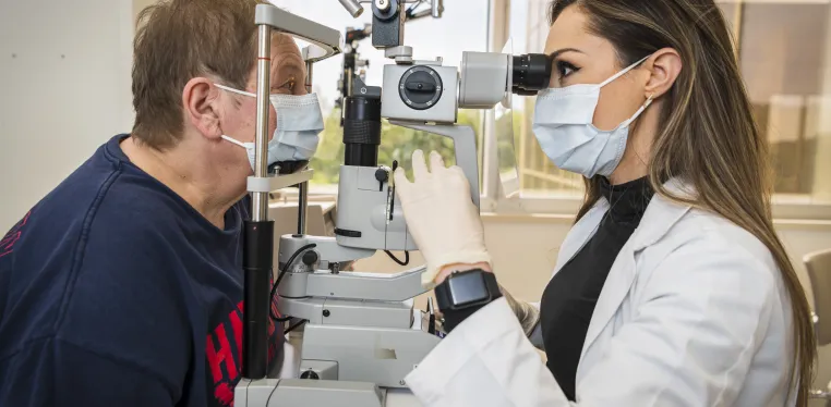 Ophthalmologist Nicole Bajic, MD, examines a patient in her clinic.