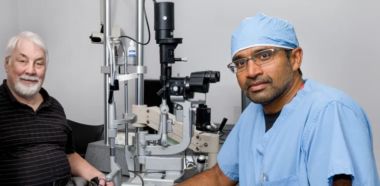 Ophthalmologist Raj Maturi, MD, with a patient in his clinic.