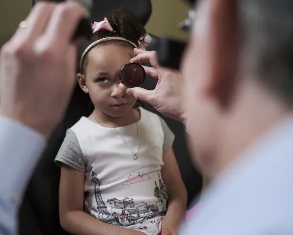 An ophthalmologist performs a pediatric eye exam