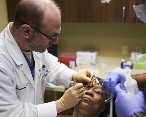 An ophthalmologist administers an eye injection