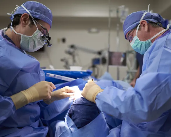 Ophthalmologist and assistant performing eye surgery