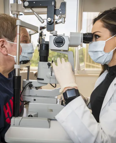 Ophthalmologist Nicole Bajic, MD, examines a patient in her clinic.
