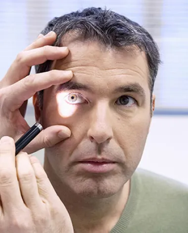 An ophthalmologist examines the eyes of a veteran patient