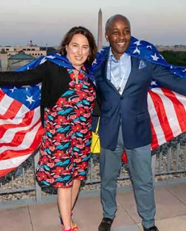 Two Academy members stand with American flags draped over their shoulders