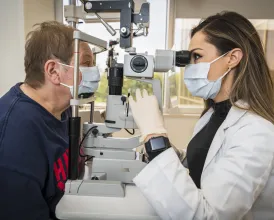 Ophthalmologist Nicole Bajic, MD, examines a patient in her clinic.