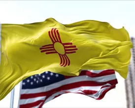 The New Mexico and United States flags fly side by side