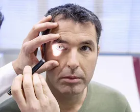 An ophthalmologist examines the eyes of a veteran patient