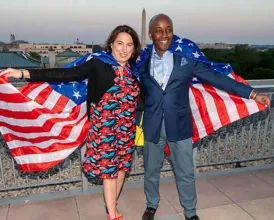 Two Academy members stand with American flags draped over their shoulders