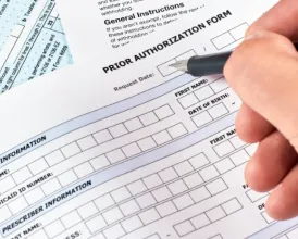 A closeup of someone filling out a prior authorization form