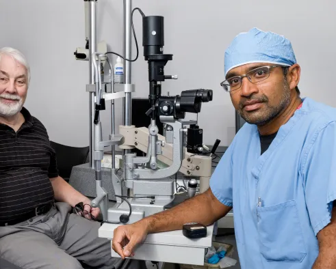 Ophthalmologist Raj Maturi, MD, with a patient in his clinic.