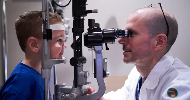 An ophthalmologist performs a pediatric vision exam